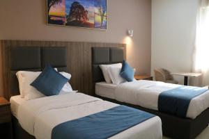 a hotel room with two beds with blue pillows at فندق منار بارك in Riyadh