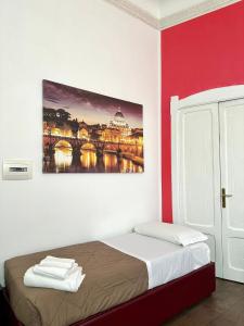 una camera da letto con un letto e un dipinto sul muro di Il Tempio Della Capitale a Roma