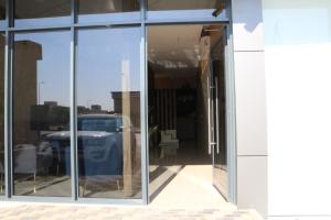 une fenêtre en verre d'un bâtiment avec une voiture à l'intérieur dans l'établissement فندق منار بارك, à Riyad