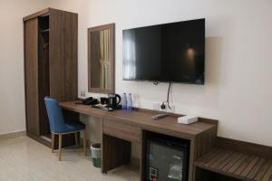 una camera d'albergo con scrivania e TV a parete di فندق منار بارك a Riyad