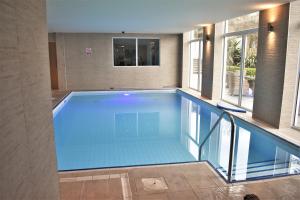 a large swimming pool in a building with a window at Belgrave Sands Hotel & Spa in Torquay