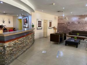 a lobby with a bar with people sitting at it at Mapungubwe Hotel Apartments Marshalltown in Johannesburg