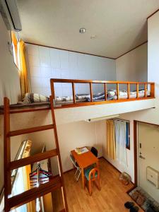 Cette chambre comprend 2 lits superposés et une table. dans l'établissement 大宮溫馨小屋, à Saitama