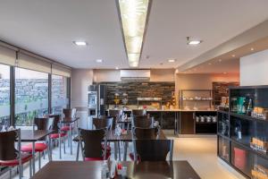 a restaurant with tables and chairs and a bar at Sol de Piedra Apart, Suites & Spa in Córdoba