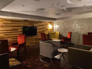 a waiting room with chairs and a flat screen tv at Mapungubwe Hotel Apartments Marshalltown in Johannesburg