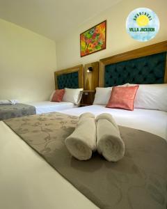 a hotel room with two beds with towels on the bed at Villa Jackson in La Tebaida