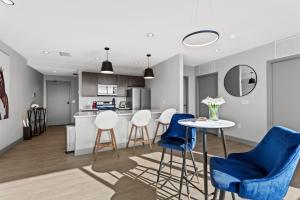 uma cozinha e sala de estar com cadeiras azuis e uma mesa em 175 LEX - Walkable Downtown Lexington & Rupp Arena - Full Condos em Lexington