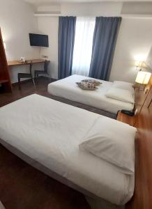 a hotel room with two beds and a desk at The Originals City, Hôtel Colmar Gare in Colmar