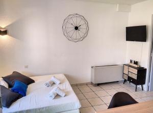 ein Schlafzimmer mit einem Bett und einer Uhr an der Wand in der Unterkunft Résidence Graziella Studio 307 in Juan-les-Pins