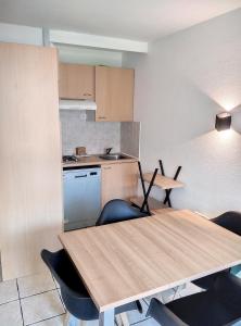 eine Küche mit einem Holztisch und Stühlen in der Unterkunft Résidence Graziella Studio 307 in Juan-les-Pins