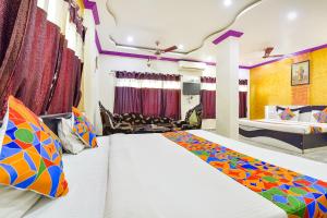 1 dormitorio con 2 camas y sala de estar en FabExpress Relax Inn I, Udaipur en Udaipur