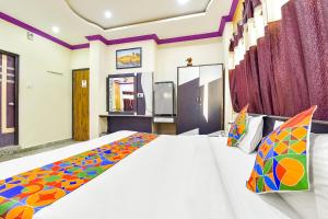 FabExpress Relax Inn I, Udaipur في أودايبور: غرفة نوم مع سرير أبيض كبير في غرفة