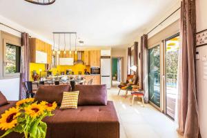 a living room with a brown couch and a kitchen at Villa Trules in Fotinós
