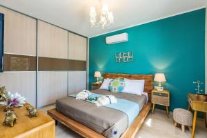 a bedroom with a bed and a blue wall at Villa Trules in Fotinós +23 photos