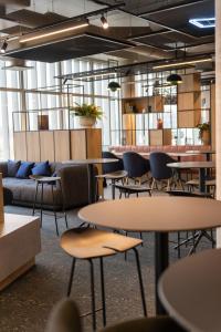 a room with tables and chairs in a building at Ibis Bourgoin Jallieu Medipole in Bourgoin