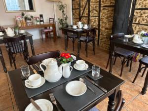 a dining room with tables and chairs with dishes on them at The Old Bakehouse in Colyton