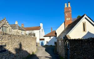 a group of buildings next to a stone wall at The Old Bakehouse in Colyton