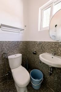 La salle de bains est pourvue de toilettes, d'un lavabo et d'un miroir. dans l'établissement Malaybalay Air’bnb Travellers Inn, à Malaybalay