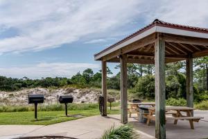 a wooden pavilion with a picnic table and two screens at The Dunes 704 in Gulf Shores +91 photos