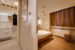 a small room with a bed and a bathroom at Le Balcon Perrière I - Charming apartment with direct view of the Thiou in Annecy