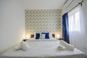 een slaapkamer met een bed met twee handdoeken erop bij Fleur Court - Sliema 4 Bedroom Side Seaviews Apartments And Penthouse By ShortLetsMalta in Sliema