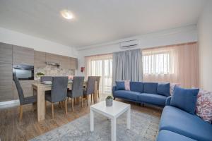 een woonkamer met een blauwe bank en een tafel bij Fleur Court - Sliema 4 Bedroom Side Seaviews Apartments And Penthouse By ShortLetsMalta in Sliema