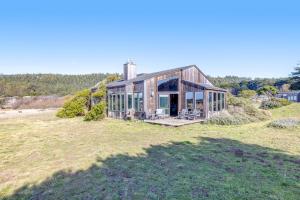 a house with glass doors on a field at Samson Getaway in Sea Ranch