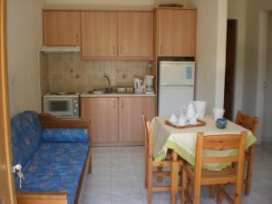 Loukas Inn Family Resort في كيري: مطبخ مع طاولة وأريكة وغرفة طعام