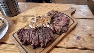 un montón de carne en una tabla de cortar en una mesa en Pod Bukovkou, en Petrov nad Desnou