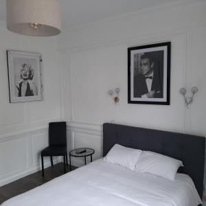 ein Schlafzimmer mit einem Bett und einem schwarz-weißen Bild in der Unterkunft Hôtel Les Beaux Arts- Limoges Hypercentre in Limoges