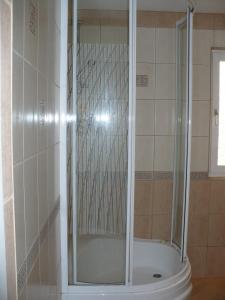 um chuveiro com uma porta de vidro na casa de banho em Kryjówka Ichuna em Werlas