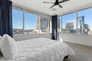 a bedroom with a white bed and large windows at 175 LEX - Walkable Downtown Lexington & Rupp Arena - Full Condos in Lexington