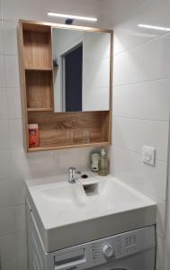 a bathroom with a white sink and a mirror at Nid douillet proche des pistes avec vue montagne in Saint-Gervais-les-Bains