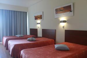 a hotel room with two beds with red sheets at Hotel Dom Afonso - Monção in Monção