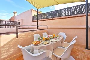 een tafel en stoelen op een balkon met een parasol bij RIAD THE MILESTONE in Marrakesh