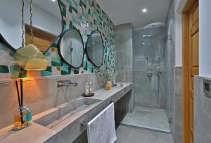 een badkamer met een wastafel en een douche met spiegels bij RIAD THE MILESTONE in Marrakesh