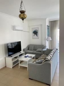a living room with a couch and a tv at Fantastic Apt-2 min walk from Belek Cent’r Antalya region, great for golf lovers in Belek