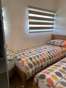 a small bedroom with two beds and a window at The View. Stylish modern Chalet in great location. in Cromer