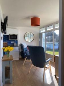 a living room with a blue chair and a desk at The View. Stylish modern Chalet in great location. in Cromer