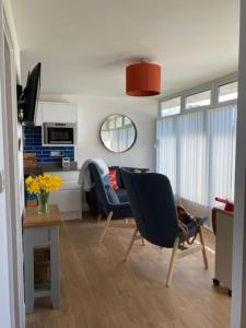 a living room with two chairs and a table at The View. Stylish modern Chalet in great location. in Cromer