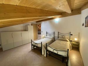 a bedroom with two beds and a wooden ceiling at La Terrazza Baldo Garda in San Zeno di Montagna