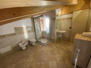 y baño con 2 aseos, ducha y lavamanos. en La Terrazza Baldo Garda, en San Zeno di Montagna