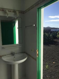 a bathroom with a white sink and a mirror at Finca mit Pool und herrlichem Meerblick in Playa Blanca