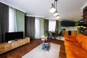 a living room with a couch and a television at Avenue Hotel - Free Parking in Sofia