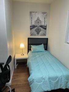a bedroom with a bed and a desk with a lamp at Brand New 2BR CUTE Blue LED in North Fresno in Fresno