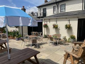 een patio met tafels en stoelen en een parasol bij The Duke of Cornwall in St Austell