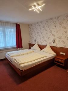 a bedroom with a bed and a window at Hotel Weinhaus Am Stiftstor in Treis-Karden