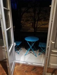 un tavolo blu e sedie di fronte a una finestra di Résidence Harmonie Appartement N 1 Haut de gamme Avec Petit Déjeuner a Néris-les-Bains