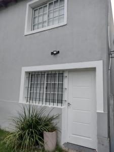 Casa blanca con puerta blanca y ventana en Departamentos Mateo en San Pedro