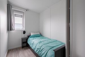a small bedroom with a bed and a window at Beau Chalet pour 4 pers - Accès piscine chauffée in Brétignolles-sur-Mer +17 photos